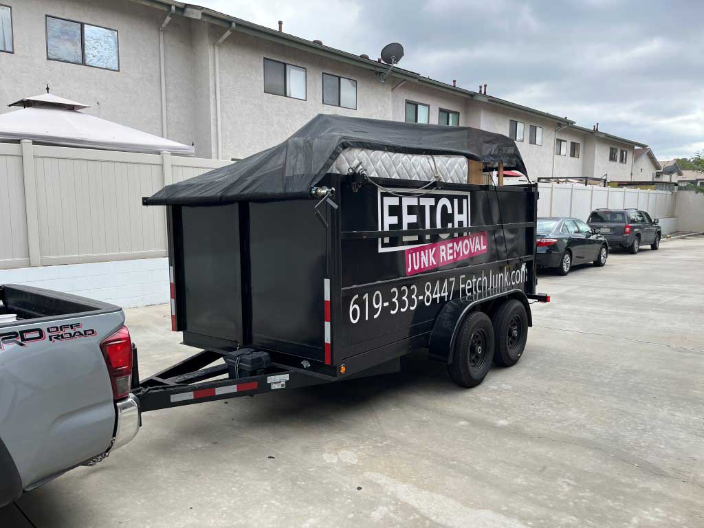 mattress and other junk removed and loaded into a black hydraulic lift trailer in Lakeside, CA